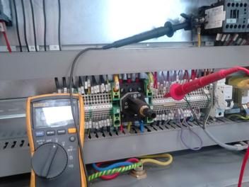 Multimeter in control panel with red and black probes