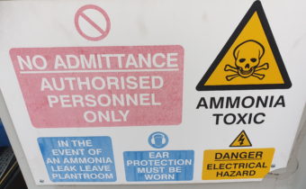 Industrial refrigeration oil change showing ammonia warning sign