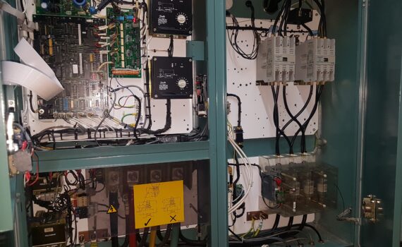 Green chiller panel with doors open, showing contactors and PCBs during water chiller maintenance