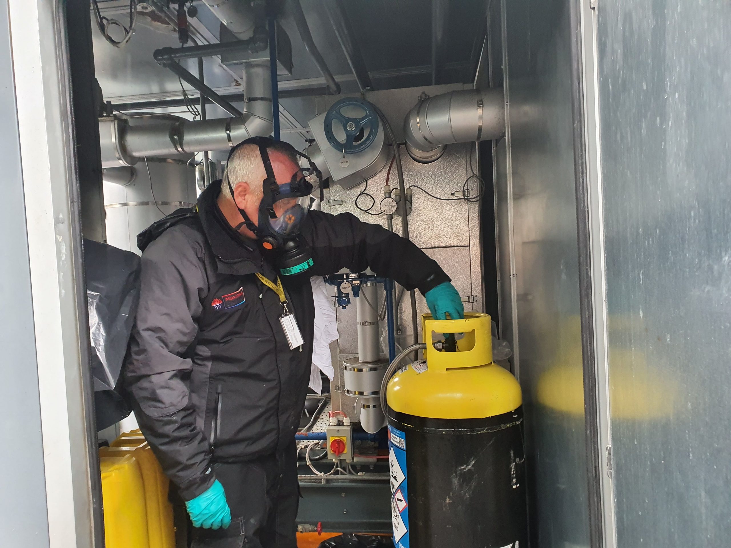 Engineer carrying out process chiller service with yellow and black cylinder