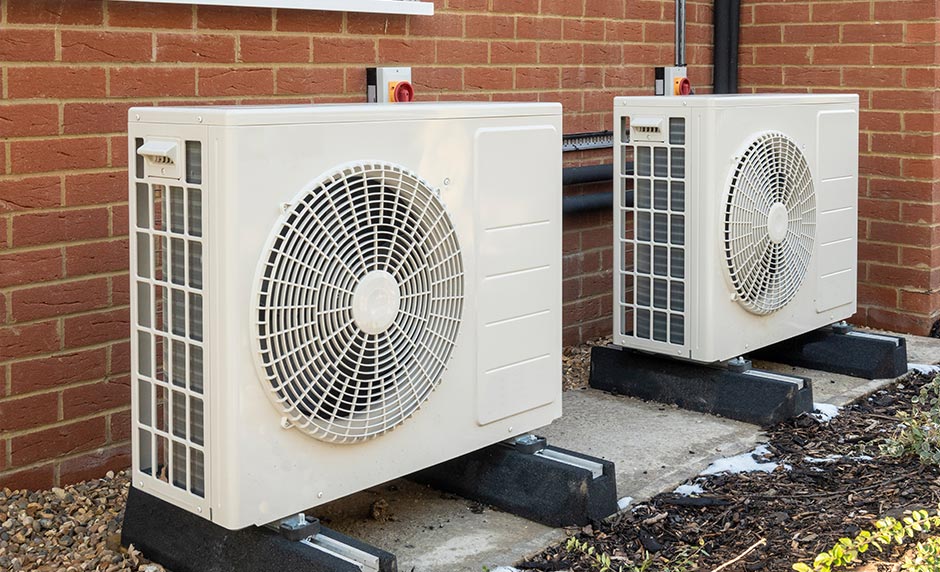 Two air conditioning condensers being installed in Manchester