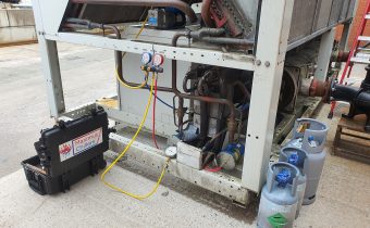 Large air cooled chiller failure showing refrigerant cylinders and vacuum pump