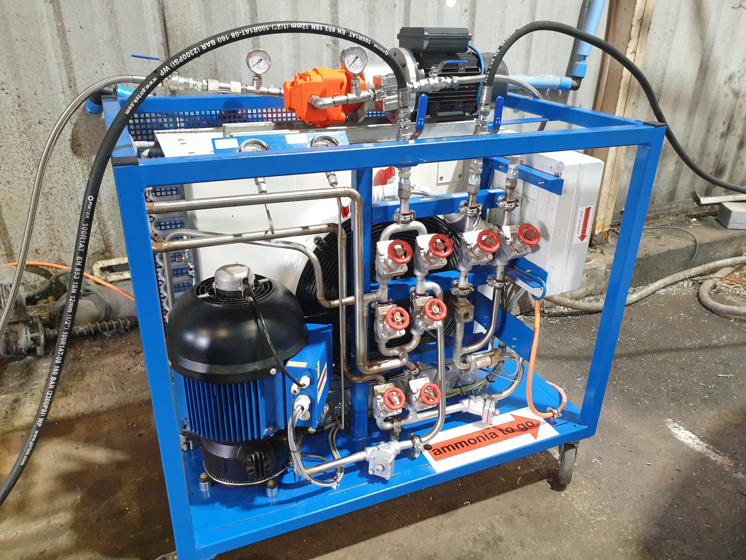 An orange ammonia liquid pump on top of a blue pump out unit
